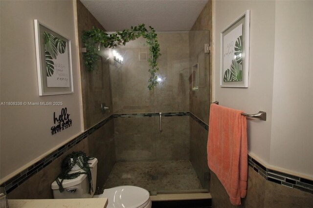3045 SW 129th Way Unit 152, Miramar, FL 33027 - full bathroom with toilet, a shower stall, a wainscoted wall, and tile walls