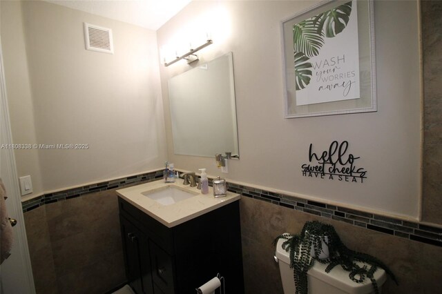 3045 SW 129th Way Unit 152, Miramar, FL 33027 - half bathroom with vanity, tile walls, toilet, and wainscoting