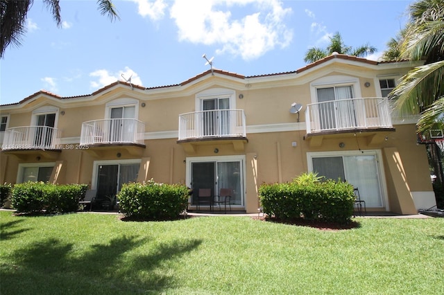 3045 SW 129th Way Unit 152, Miramar, FL 33027 - rear view of house featuring stucco siding, a lawn, and a balcony