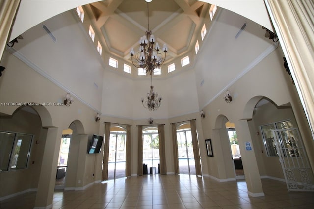 3045 SW 129th Way Unit 152, Miramar, FL 33027 - unfurnished living room with a chandelier, arched walkways, tile patterned floors, a towering ceiling, and baseboards