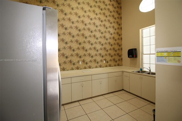 3045 SW 129th Way Unit 152, Miramar, FL 33027 - kitchen with freestanding refrigerator, light countertops, wallpapered walls, a sink, and white cabinetry