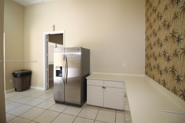 3045 SW 129th Way Unit 152, Miramar, FL 33027 - kitchen with stainless steel fridge with ice dispenser, light countertops, light tile patterned flooring, wallpapered walls, and white cabinetry