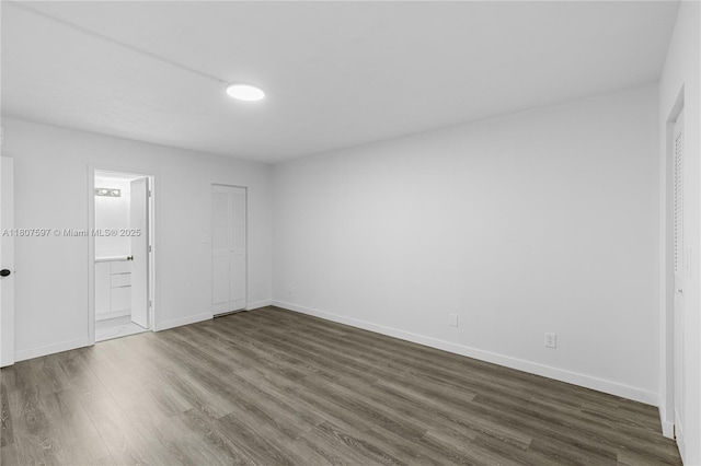 3591 Inverrary Dr Unit 203, Lauderhill, FL 33319 - unfurnished bedroom with dark wood finished floors, baseboards, and connected bathroom