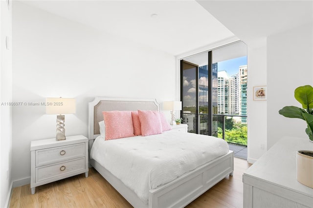 2678 Tigertail Ave Unit 713, Miami, FL 33133 - bedroom with access to outside, expansive windows, light wood-style floors, a view of city, and baseboards