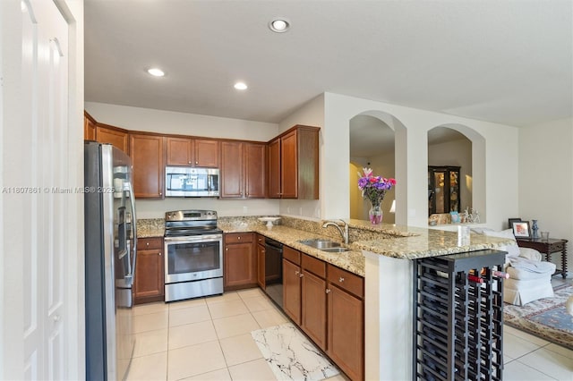 9618 Waterview Way, Parkland, FL 33076 - kitchen with appliances with stainless steel finishes, a sink, light tile patterned flooring, light stone countertops, and a peninsula