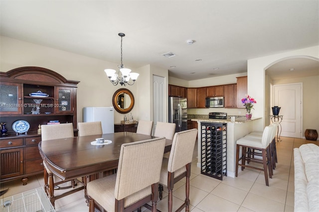 9618 Waterview Way, Parkland, FL 33076 - dining area featuring arched walkways, light tile patterned floors, and a chandelier