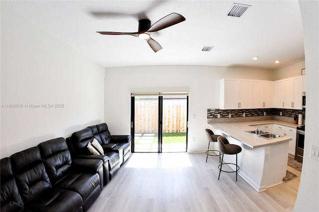 21068 NE 8th Ave, Miami, FL 33179 - kitchen with a sink, a kitchen breakfast bar, open floor plan, light wood finished floors, and recessed lighting