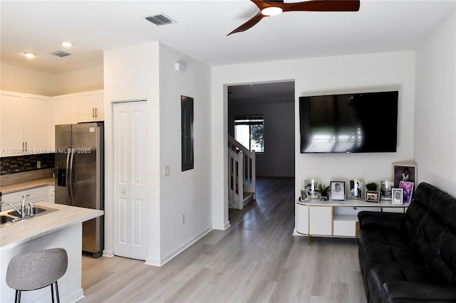 21068 NE 8th Ave, Miami, FL 33179 - living area featuring light wood-type flooring, stairway, electric panel, ceiling fan, and baseboards