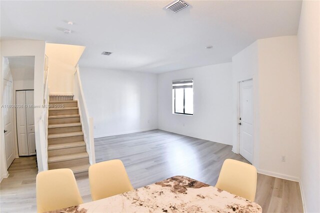 21068 NE 8th Ave, Miami, FL 33179 - dining space with light wood-style floors, stairs, and baseboards