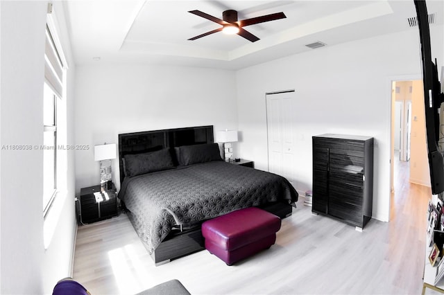 21068 NE 8th Ave, Miami, FL 33179 - bedroom with a tray ceiling, wood finished floors, a closet, and ceiling fan