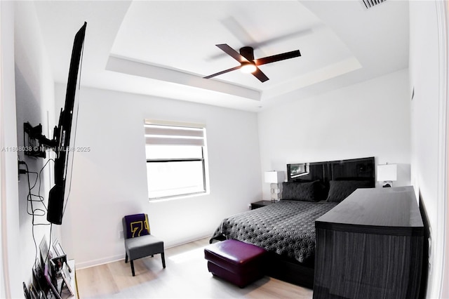 21068 NE 8th Ave, Miami, FL 33179 - bedroom with a tray ceiling, a ceiling fan, and wood finished floors