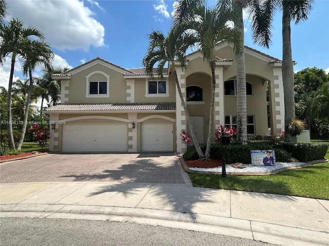 3945 Heron Ridge Ln, Weston, FL 33331 - view of front of house with stucco siding, an attached garage, decorative driveway, and a tiled roof