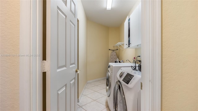 3945 Heron Ridge Ln, Weston, FL 33331 - washroom featuring cabinet space, washing machine and dryer, light tile patterned floors, and a textured wall