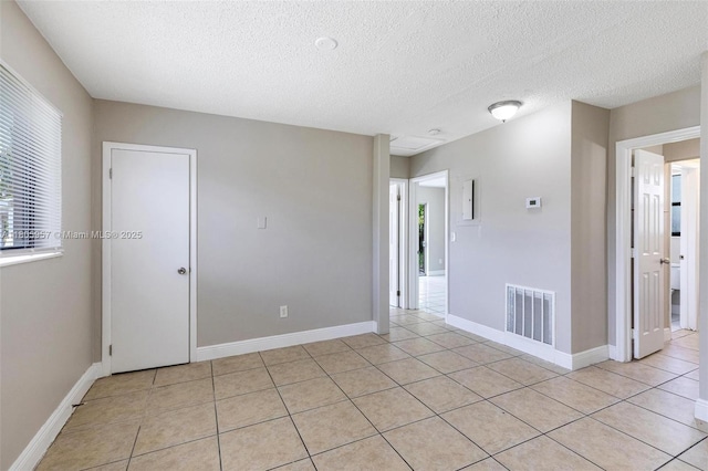 4960 NW 11th Ct, Lauderhill, FL 33313 - spare room featuring healthy amount of natural light, a textured ceiling, light tile patterned floors, and baseboards