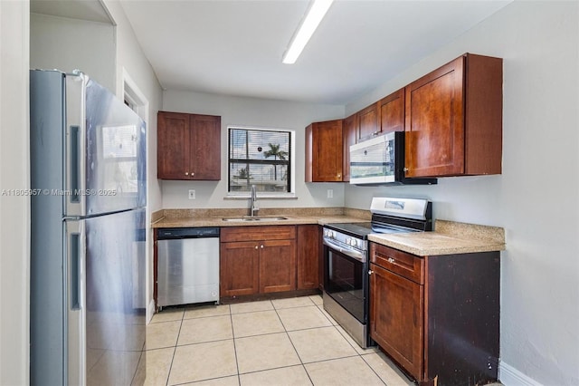 4960 NW 11th Ct, Lauderhill, FL 33313 - kitchen with stainless steel appliances, a sink, light tile patterned flooring, and light countertops