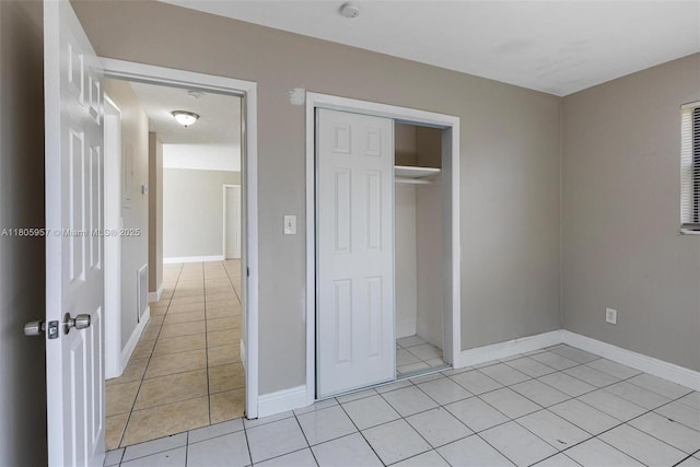 4960 NW 11th Ct, Lauderhill, FL 33313 - unfurnished bedroom with light tile patterned flooring, a closet, and baseboards