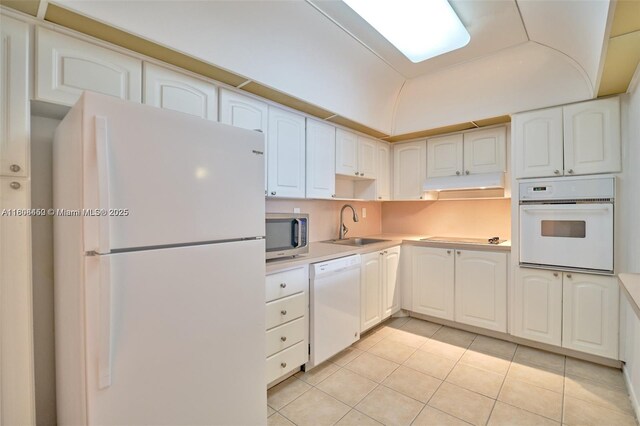 19390 Collins Ave Unit 217, Sunny Isles Beach, FL 33160 - kitchen featuring white appliances, a sink, light tile patterned flooring, under cabinet range hood, and light countertops