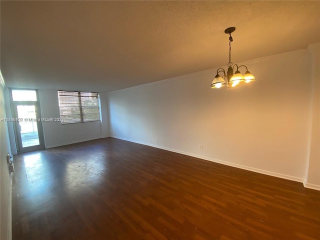 19390 Collins Ave Unit 217, Sunny Isles Beach, FL 33160 - spare room with a chandelier, dark wood-type flooring, baseboards, and ornamental molding