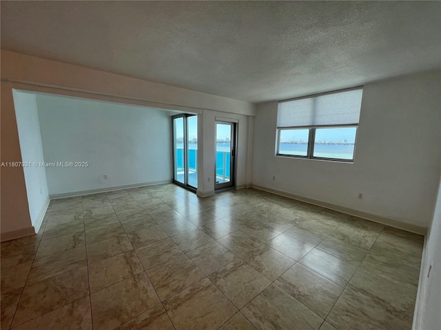 7501 E Treasure Dr Unit 9D, North Bay Village, FL 33141 - empty room with a textured ceiling and baseboards