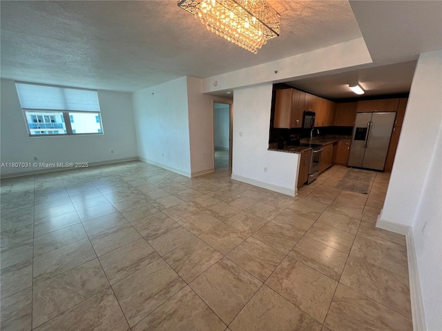 7501 E Treasure Dr Unit 9D, North Bay Village, FL 33141 - kitchen with stainless steel appliances, open floor plan, a textured ceiling, dark countertops, and a chandelier