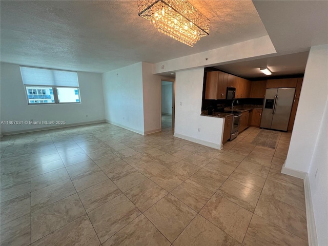 7501 E Treasure Dr Unit 9D, North Bay Village, FL 33141 - kitchen featuring appliances with stainless steel finishes, a textured ceiling, open floor plan, dark countertops, and a chandelier