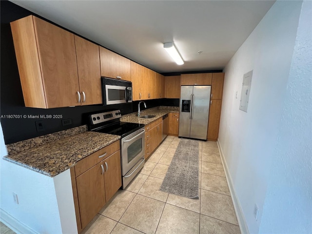 7501 E Treasure Dr Unit 9D, North Bay Village, FL 33141 - kitchen with appliances with stainless steel finishes, a sink, baseboards, and dark stone counters