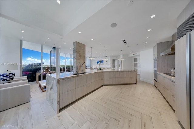10225 Collins Ave Unit 604, Bal Harbour, FL 33154 - kitchen with modern cabinets, open floor plan, light brown cabinetry, a sink, and light stone countertops