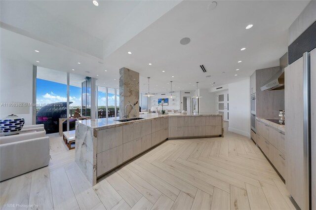 10225 Collins Ave Unit 604Renovated, Bal Harbour, FL 33154 - kitchen with modern cabinets, open floor plan, light brown cabinets, wall chimney exhaust hood, and double oven