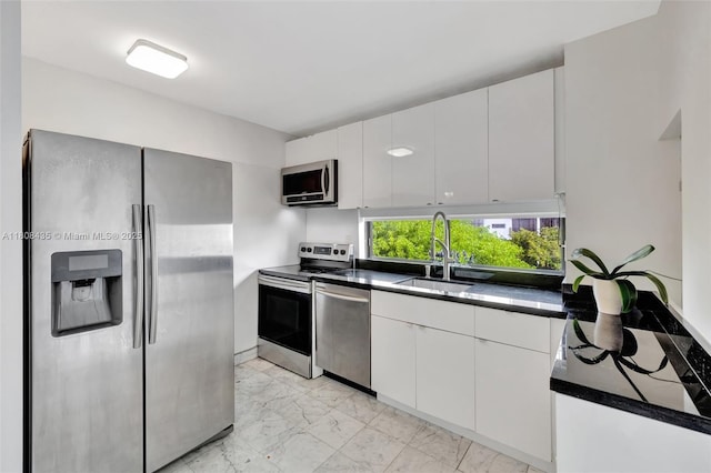 16919 N Bay Rd Unit 521, Sunny Isles Beach, FL 33160 - kitchen featuring appliances with stainless steel finishes, a sink, light marble finish flooring, dark countertops, and white cabinets