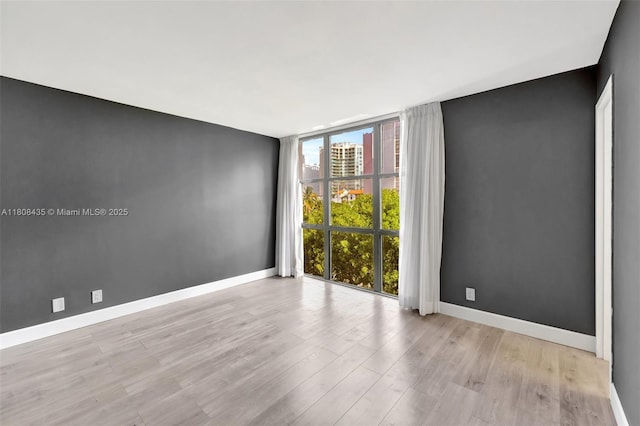 16919 N Bay Rd Unit 521, Sunny Isles Beach, FL 33160 - empty room with floor to ceiling windows, wood finished floors, baseboards, and a city view