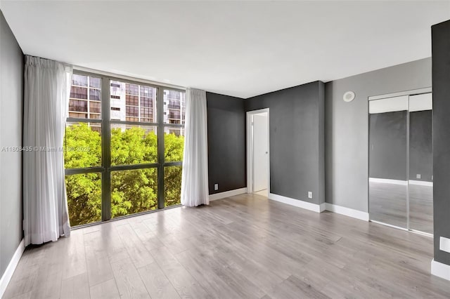 16919 N Bay Rd Unit 521, Sunny Isles Beach, FL 33160 - unfurnished bedroom with a wall of windows, wood finished floors, and baseboards