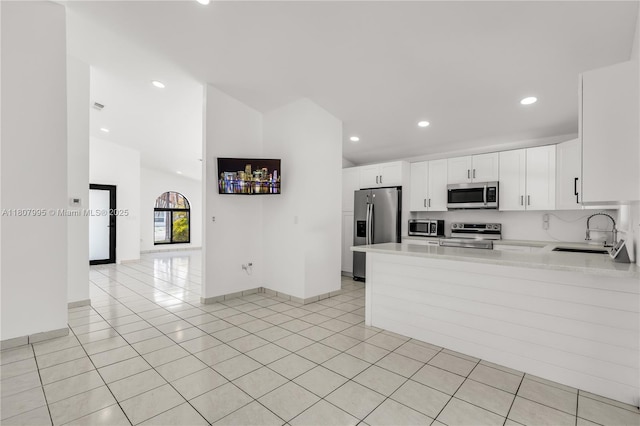 14234 SW 49th St, Miami, FL 33175 - kitchen featuring appliances with stainless steel finishes, a sink, light countertops, white cabinetry, and a peninsula