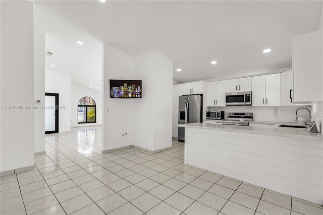 14234 SW 49th St, Miami, FL 33175 - kitchen featuring stainless steel appliances, a sink, light countertops, white cabinets, and a peninsula