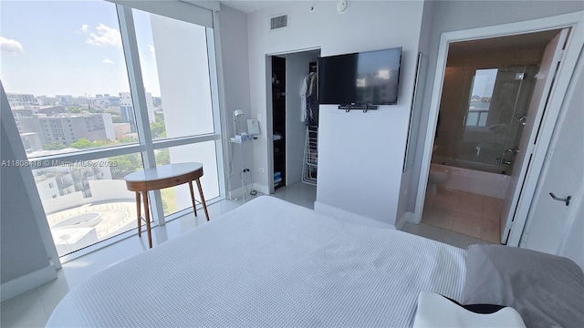 480 NE 30th St Unit 1405, Miami, FL 33137 - tiled bedroom featuring a walk in closet, a closet, ensuite bath, and a city view