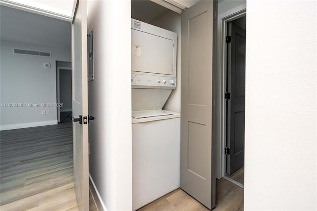 950 Brickell Bay Dr Unit 4007, Miami, FL 33131 - laundry room with stacked washer / dryer, light wood-style floors, and baseboards