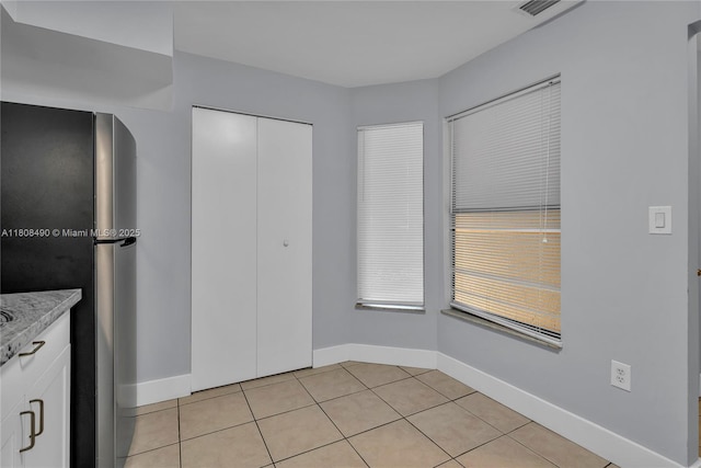 2288 SW 81st Ave Unit 2288, Miramar, FL 33025 - kitchen featuring freestanding refrigerator, white cabinetry, light tile patterned flooring, light countertops, and baseboards
