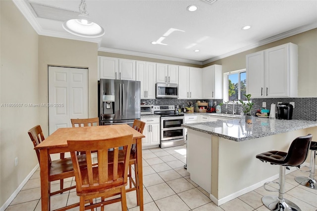 1874 NW 74th Way, Pembroke Pines, FL 33024 - kitchen featuring appliances with stainless steel finishes, a peninsula, decorative backsplash, white cabinets, and ornamental molding