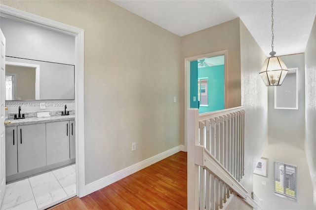 1874 NW 74th Way, Pembroke Pines, FL 33024 - hallway featuring an upstairs landing, a sink, baseboards, and light wood-style flooring