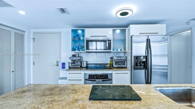 185 SW 7th St Unit 2911, Miami, FL 33130 - kitchen featuring appliances with stainless steel finishes, tasteful backsplash, white cabinetry, light stone countertops, and recessed lighting