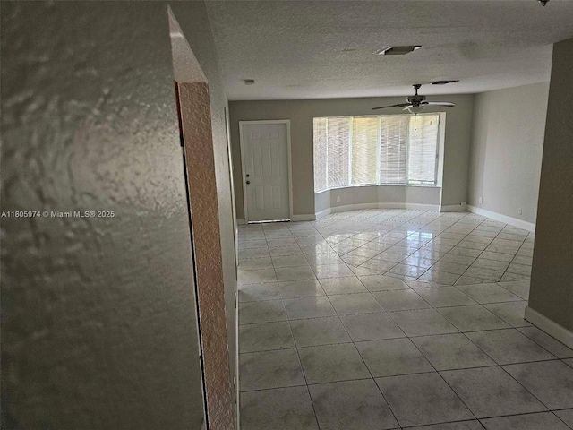 5960 NW 14th St, Sunrise, FL 33313 - tiled spare room featuring a ceiling fan, baseboards, and a textured ceiling