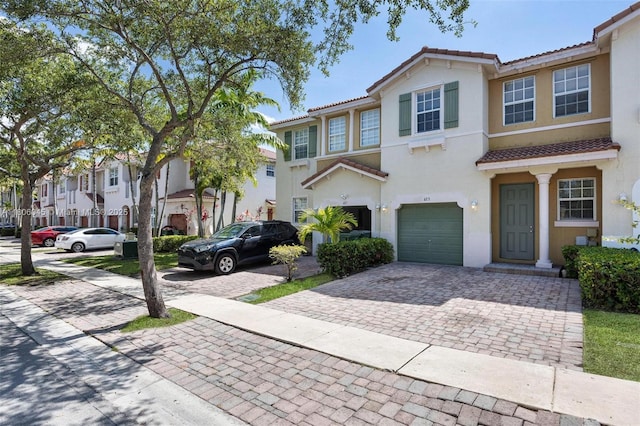 623 NE 21st Ter, Homestead, FL 33033 - view of property featuring decorative driveway, a tile roof, a garage, and stucco siding
