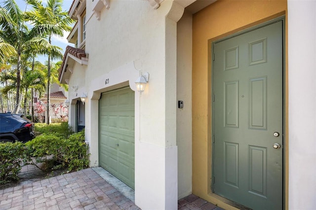 623 NE 21st Ter, Homestead, FL 33033 - view of exterior entry with stucco siding and an attached garage