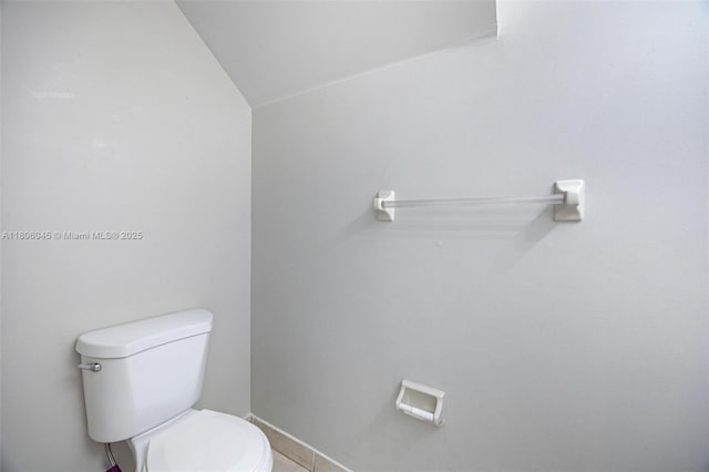 623 NE 21st Ter, Homestead, FL 33033 - bathroom featuring toilet, baseboards, tile patterned floors, and vaulted ceiling