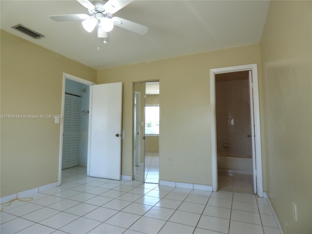 9023 NW 113th St, Hialeah Gardens, FL 33018 - unfurnished bedroom with baseboards, light tile patterned flooring, ensuite bathroom, and ceiling fan