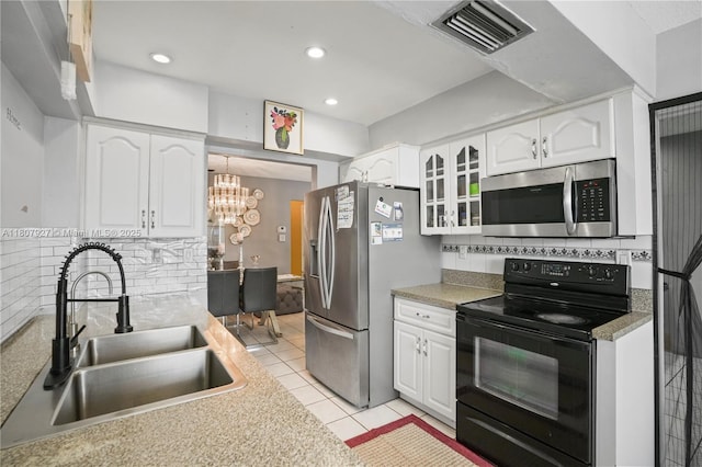 5390 SW 10th Ct, Margate, FL 33068 - kitchen featuring appliances with stainless steel finishes, a sink, white cabinets, light tile patterned flooring, and backsplash