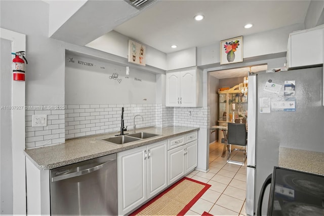 5390 SW 10th Ct, Margate, FL 33068 - kitchen featuring stainless steel appliances, a sink, light tile patterned flooring, white cabinets, and tasteful backsplash