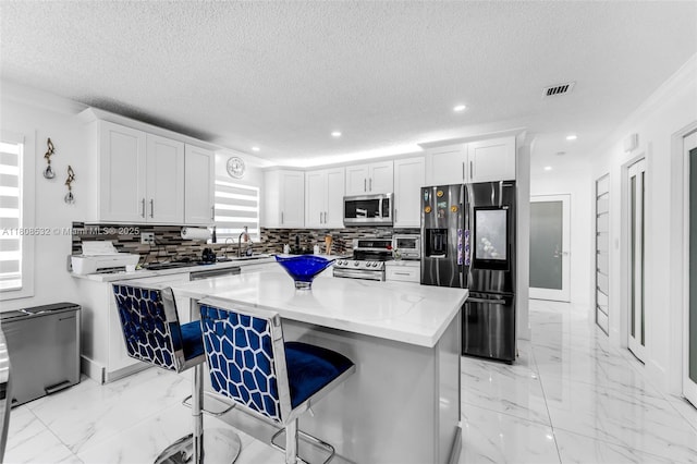 9304 SW 166th Ter, Palmetto Bay, FL 33157 - kitchen featuring stainless steel appliances, backsplash, a textured ceiling, white cabinets, and recessed lighting