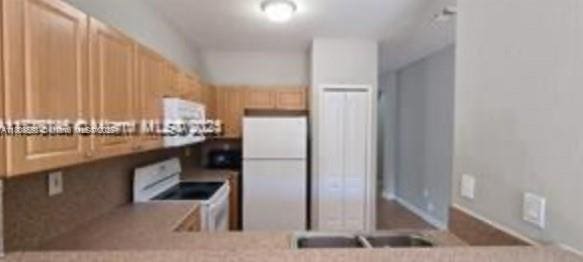 2903 SE 17th Ave Unit 102, Homestead, FL 33035 - kitchen featuring white appliances, light brown cabinetry, and light countertops