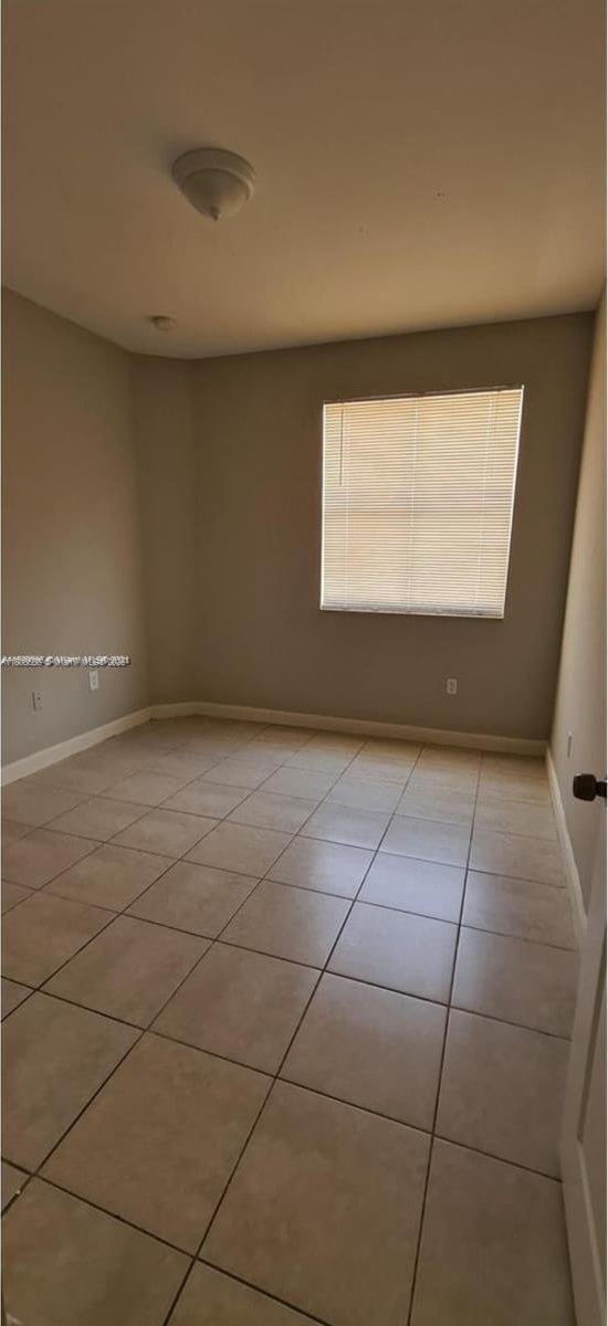 2903 SE 17th Ave Unit 102, Homestead, FL 33035 - empty room with light tile patterned floors and baseboards