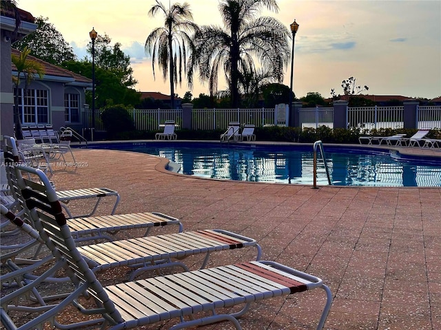 5031 Wiles Rd Unit 304, Coconut Creek, FL 33073 - pool at dusk featuring a community pool and a patio